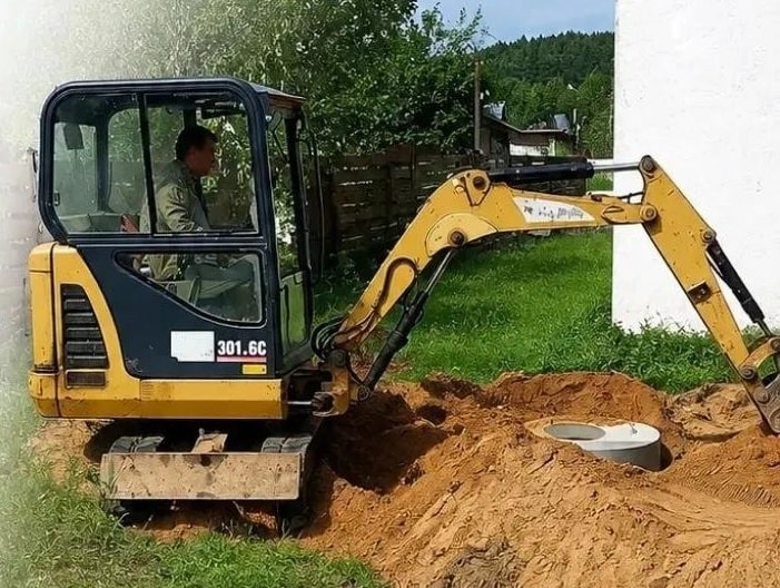 Мини-экскаватор Caterpillar 301.6C на участке, копка колец и траншей